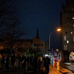 Straße mit Luisentor und Demonstranten der Mahnwache für den Frieden bei Nacht