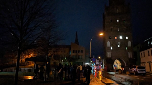 Straße mit Luisentor und Demonstranten der Mahnwache für den Frieden bei Nacht
