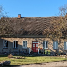 Gutshaus Waldberg mit zwei Bäumen vor blauem Himmel