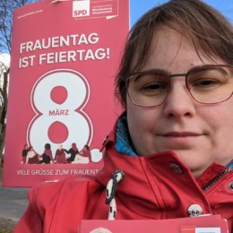 AK Schröder mit Flyern vor einem Plakat zum Frauentag 2023
